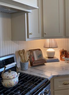 a kitchen with an oven, tea kettle and utensils on the counter top