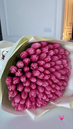 a bouquet of pink tulips in a paper bag