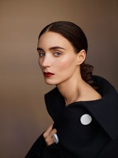 a woman wearing a black coat and red lipstick