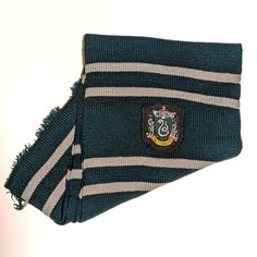 a green and white striped scarf with a crest on the front, sitting against a white background