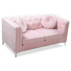 a pink couch with two pillows on the back and one pillow on the armrest