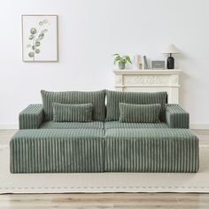 a green couch sitting on top of a wooden floor