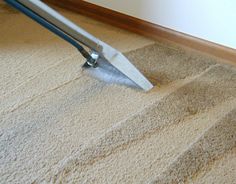 a person using a vacuum to clean carpet