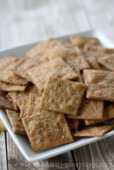 crackers on a white plate sitting on a wooden table