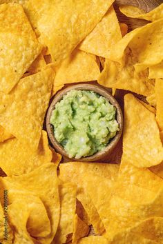 a bowl filled with guacamole surrounded by tortilla chips