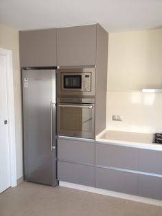 a modern kitchen with stainless steel appliances and white counter tops, along with beige tile flooring