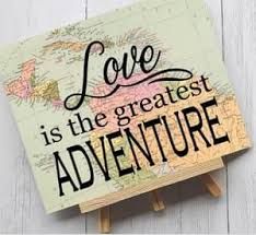 a wooden easel with the words love is the greatest adventure on it and a world map