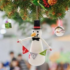 a snowman ornament hanging from a christmas tree