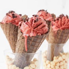 three cones filled with ice cream sitting on top of a table next to white chocolate chips