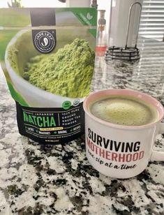 a cup of green tea sitting on top of a counter next to a bag of matcha