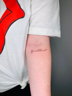 a woman's arm with a small tattoo on the left side of her arm