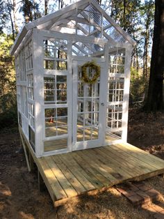 a small white house sitting on top of a wooden platform