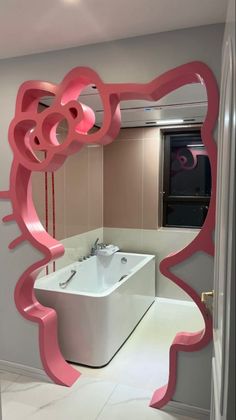 a bathroom with a pink mirror and white bathtub in the middle of the room