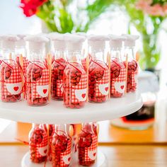 there are many bottles with candy in them on the table and one is filled with hearts