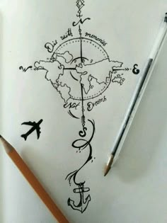 a drawing of an anchor and compass on paper with a pencil in front of it