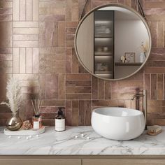 a bathroom with a round mirror and marble counter top