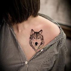 a woman with a wolf tattoo on her shoulder