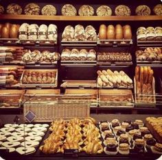 a bakery filled with lots of different types of breads and pastries on display