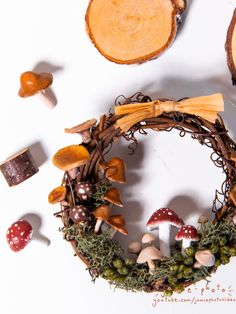 a wreath with mushrooms and leaves on it next to other items that are arranged around it