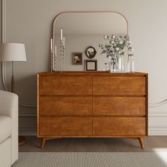 a wooden dresser sitting next to a white couch