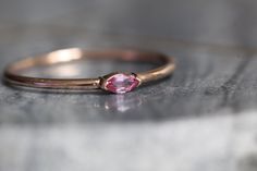 "A dainty marquise pink sapphire is at the center of our \"Wink\" ring, giving you just a little wink of sparkle! - Marquise stone measures 4mm x 2mm - Handcrafted out of 14K yellow, rose, or white gold - Round band measures 1.2mm in width Processing Times - Current processing time is 1 - 3 weeks. Each Item is handmade to order with love and care! In Stock Items - Contact Liesel Love with any rush order questions, or to see if we have anything ready made and in stock. Returns - Liesel Love does Fine Jewelry Marquise Pink Gemstone, Marquise Pink Rings With Accent Stones, Fine Jewelry Pink Marquise Ruby Ring, Pink Marquise Ruby Ring Fine Jewelry, Pink Marquise Promise Ring, Marquise Rose Cut Diamond Rings In Pink, Pink Marquise Gemstone Rings, Pink Marquise Ring With Rose Cut Diamonds, Pink Marquise Rose Cut Diamond Rings