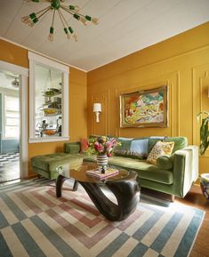 a living room with yellow walls and furniture