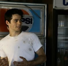 a man standing in front of a pepsi sign