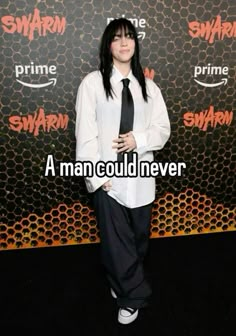 a man with long black hair wearing a white shirt and tie standing in front of a wall