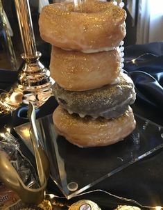 a stack of doughnuts sitting on top of a black tray next to a candle