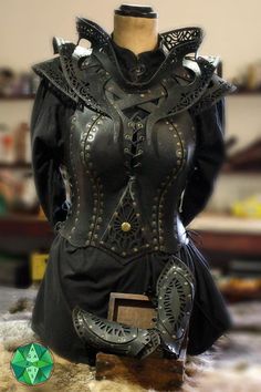 a mannequin is dressed in black leather and has ornate details on the bust