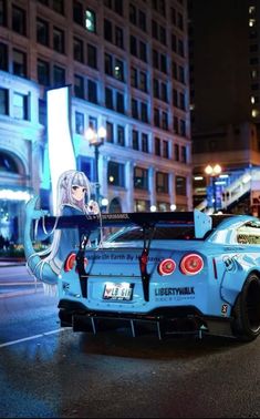 a blue car parked in front of a tall building on a city street at night