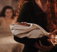 a woman with long red hair holding a baby