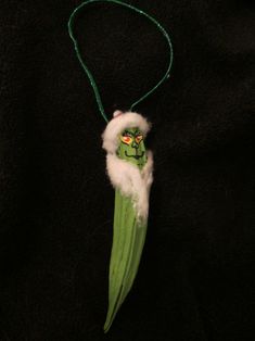 an ornament made to look like a peal with a green face and white fluffy tail