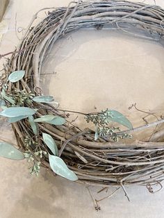 a close up of a wreath on the ground with leaves and twigs attached to it