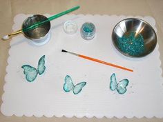 the table is set up with butterflies painted on it and two bowls are next to each other