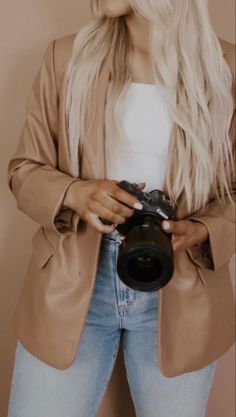 a woman with blonde hair is holding a camera