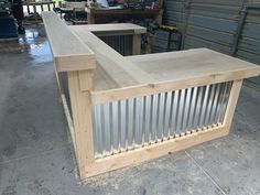 an unfinished bar made out of plywood and metal sheeting in a garage area