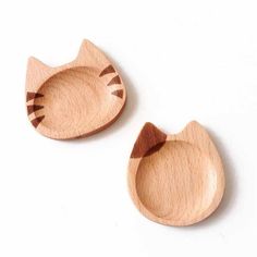 two wooden cat shaped dishes sitting next to each other