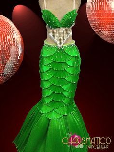 a green dress on display in front of disco balls