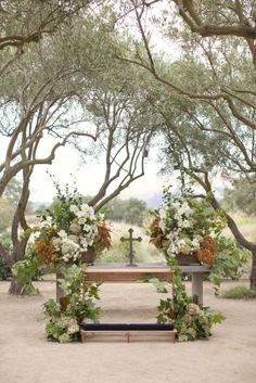 a wooden bench with flowers and greenery on it