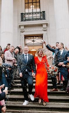 a newly married couple walking down the steps with confetti thrown in the air