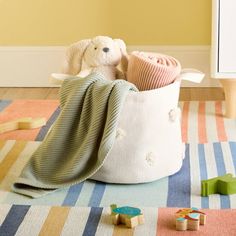 a teddy bear sitting in a blanket on the floor