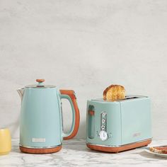 two toasters with bread in them sitting next to each other on a marble counter