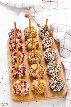 an assortment of appetizers on a cutting board with toothpicks in them