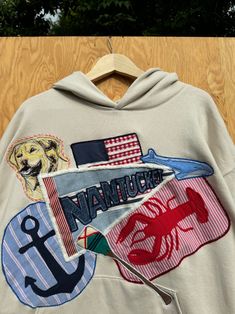 the back of a sweatshirt with an anchor, flag and dog on it