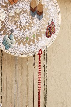 a white table topped with lots of different necklaces and earring hooks hanging from it's sides