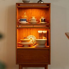 a wooden shelf filled with dishes and cups