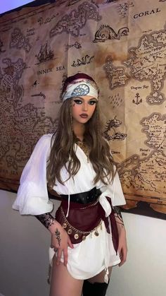 a woman dressed up as a pirate in front of a wall with an old map