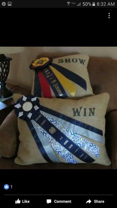 two pillows with ribbons on them sitting on a couch