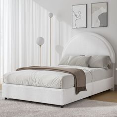 a white bed sitting in a bedroom next to a window